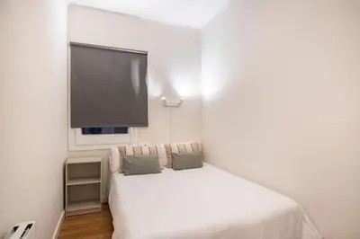a bedroom with a white bed with a flat screen tv at Comfortable 3-Bedroom Apartment next to Sagrada Familia, Barcelona in Barcelona