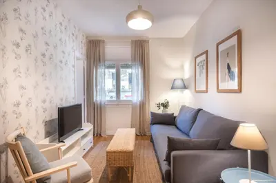 a living room with a blue couch and a tv at Comfortable 3-Bedroom Apartment next to Sagrada Familia, Barcelona in Barcelona
