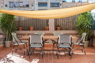 a wooden table and four chairs on a patio at Sunny Central Apartment with 100sqm Terrace in Barcelona in Barcelona