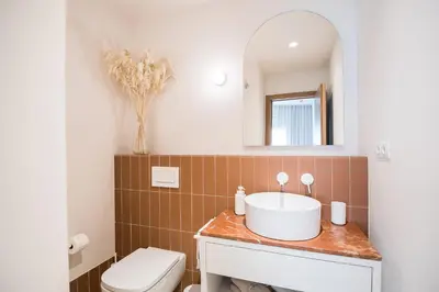 a bathroom with a sink and a toilet and a mirror at Mediterranean Retreat with 4-Bedroom, 3-Bath Apartment in Barcelona in Barcelona