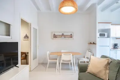 a white living room with a table and chairs at Cozy Apartment in the Heart of Gracia, Barcelona in Barcelona