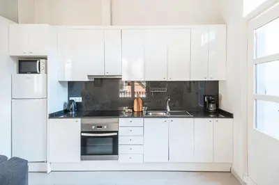 a white kitchen with white cabinets and a sink at Cozy Apartment with Terrace in Gracia, Barcelona Local Life in Barcelona