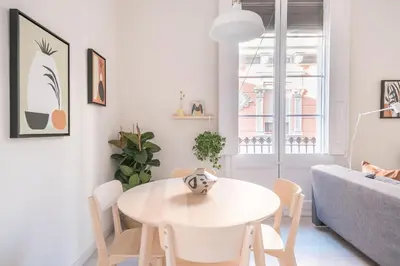 a white living room with a white table and chairs at Cozy Apartment with Terrace in Gracia, Barcelona Local Life in Barcelona