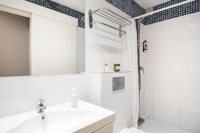 a white bathroom with a shower and a sink at Oasis with a terrace in the heart of Gracia, Barcelona in Barcelona