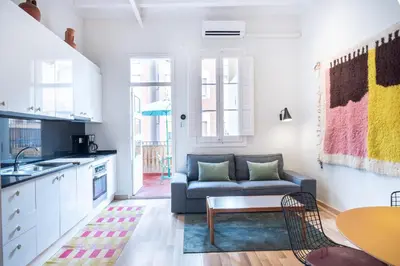 a kitchen and living room with a couch and a table at Oasis with a terrace in the heart of Gracia, Barcelona in Barcelona