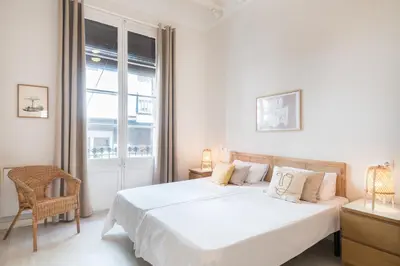 a white bedroom with a large bed and a window at Sunny Apartment with Private Terrace in Gracia, Barcelona in Barcelona