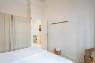 a white bedroom with a bed and a door at Sunny Apartment with Private Terrace in Gracia, Barcelona in Barcelona