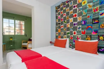 a bedroom with a large bed with a colorful wall at Charming 3 Bdr-2 Bthr In Gracia in Barcelona