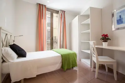 a bedroom with a bed and a desk and a chair at BCNGOTIC 31 in Barcelona