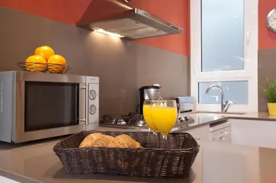 a kitchen with a basket of bread and a glass of orange juice at BCNGOTIC 33 in Barcelona