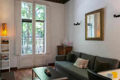 a living room with a couch and a mirror at AB Casanova Apartment in Barcelona
