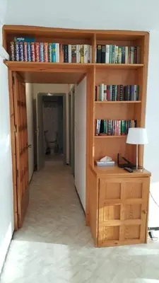 a room with a book shelf with books at Apart 2 habit vistas playa y montaña lift parking in Calella