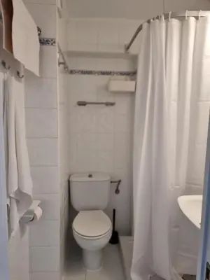 a white bathroom with a toilet and a sink at Apart 2 habit vistas playa y montaña lift parking in Calella