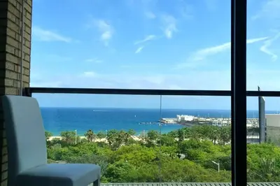 a room with a view of the ocean from a window at Sea views & city skyline in Barcelona