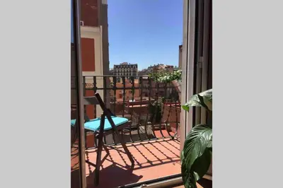 a balcony with a chair and a view of a city at Sunny apartment Gracia - Joanic Renovated in Barcelona