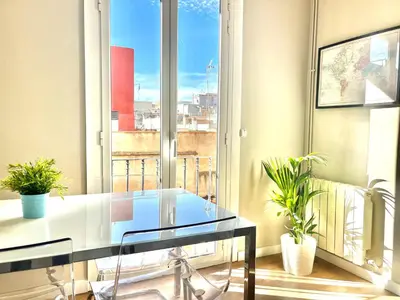 a glass table in front of a window with plants at Sunny apartment Gracia - Joanic Renovated in Barcelona