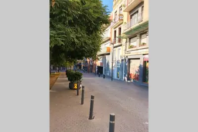 a street with a row of poles on the sidewalk at 2 BEDROOM APARTMENT SANTS in Barcelona