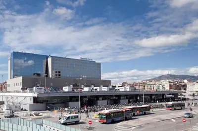 a parking lot with buses parked in front of a building at 2 BEDROOM APARTMENT SANTS in Barcelona