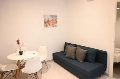a living room with a blue couch and a table at Homenfun Barcelona Les Corts in Barcelona