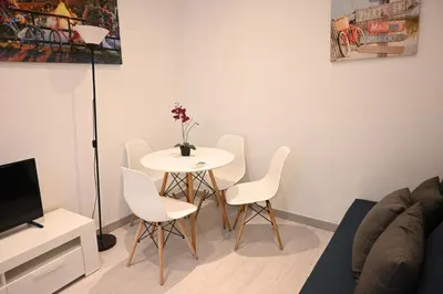 a living room with a table and white chairs at Homenfun Barcelona Les Corts in Barcelona