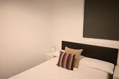 a bed with a black headboard and a pillow on it at Homenfun Barcelona Les Corts in Barcelona