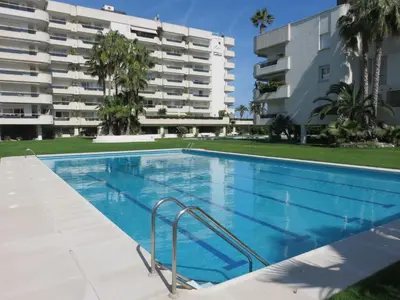 a swimming pool in front of a apartment building at Mediterraneo Seaview Apartment by Hello Homes Sitges in Sitges