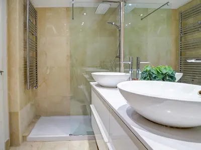 a bathroom with two sinks and a shower at Mediterraneo Seaview Apartment by Hello Homes Sitges in Sitges