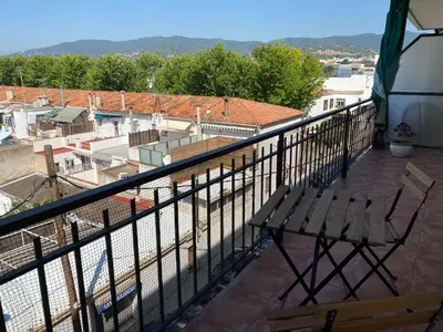 a balcony with a bench and a view of a city at Vilamarlux V in Vilassar de Mar