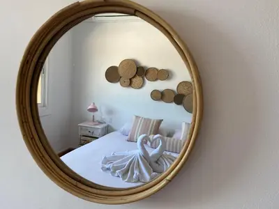 a mirror in a bedroom with a bed and a bed at Vilamarlux V in Vilassar de Mar