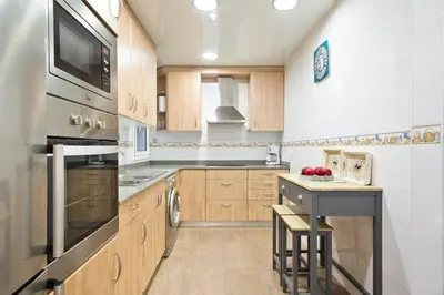 a kitchen with wooden cabinets and a stove top oven at Stay U-nique Apartments Mallorca in Barcelona