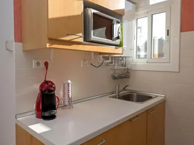 a kitchen counter with a sink and a microwave at Apartment Sagrada Familia Grassot - Industria by Interhome in Barcelona
