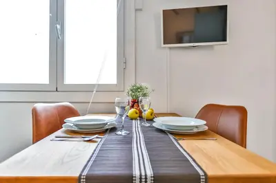 a dining room table with plates and glasses on it at Ghat Apartments Montroig in Sitges