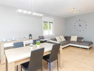 a dining room and living room with a table and a couch at Holiday Home Nova by Interhome in Segur de Calafell