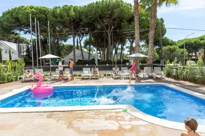 a swimming pool with a pink swan and a pink flamingo at Aparthotel Las Palmeras Castelldefels in Castelldefels
