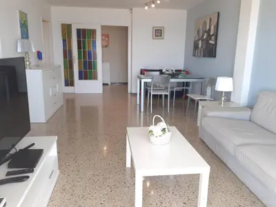 a living room with a couch and a table at Suitur apartamento primera linea mar vistas playa in Canet de Mar