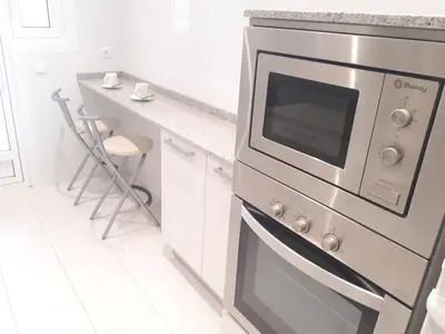 a kitchen with a stainless steel oven and a counter at Suitur apartamento primera linea mar vistas playa in Canet de Mar