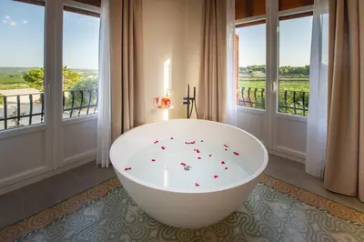 a bath tub in a room with windows at Bolet Casa Modernista in Castellví de la Marca