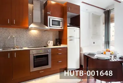 a kitchen with wooden cabinets and a stove top oven at Ghat Apartment Poble Sec Barcelona in Barcelona