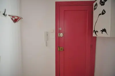 a red door in a room with a wall at Apartamento Parc Güell in Barcelona