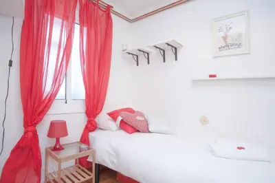 a bedroom with red curtains and a bed at Apartamento Parc Güell in Barcelona