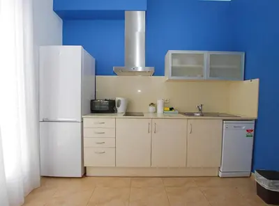 a kitchen with a white refrigerator and a blue wall at La Platgeta · La Platgeta · Ideal family apartment, with private terrace in Vilassar de Mar
