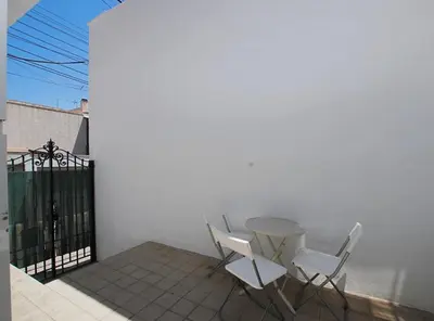 two white chairs and a table on a balcony at La Platgeta · La Platgeta · Ideal family apartment, with private terrace in Vilassar de Mar