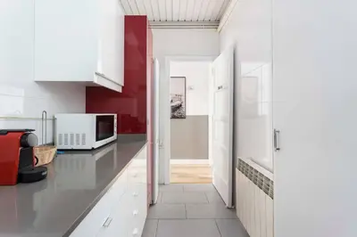 a kitchen with white cabinets and a microwave at Stylish 3 Bedroom Apartment in Barcelona