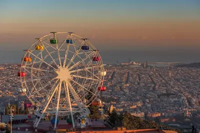 a ferris wheel sitting on top of a city at MUNTANYA - Apartments & one with Terrace next to Sagrada Familia in Barcelona