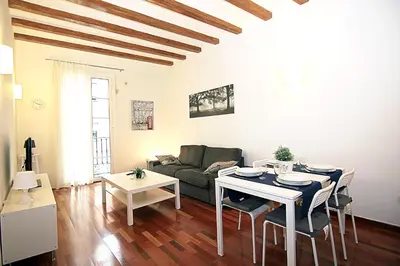 a living room with a table and a couch at MUNTANYA - Apartments & one with Terrace next to Sagrada Familia in Barcelona