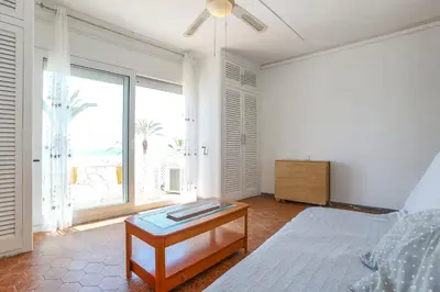 a white bedroom with a bed and a table at Apart Cozy On The Front Line, Liliane in Sitges