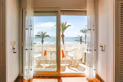 a room with a balcony with a view of the ocean at Apart Cozy On The Front Line, Liliane in Sitges