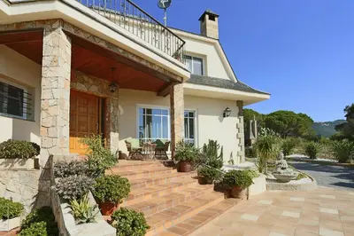 a house with a porch with potted plants at Homestay Villa Estrella - Costa Brava in Calella