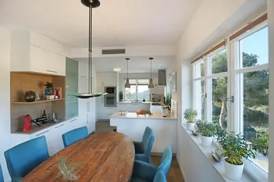 a kitchen and dining room with a wooden table and chairs at Homestay Villa Estrella - Costa Brava in Calella