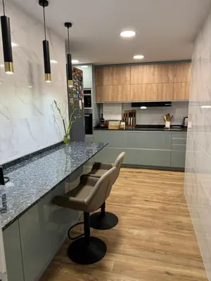 a kitchen with a counter and a bar with a chair at Habitación Amaya 1 in Las Corts